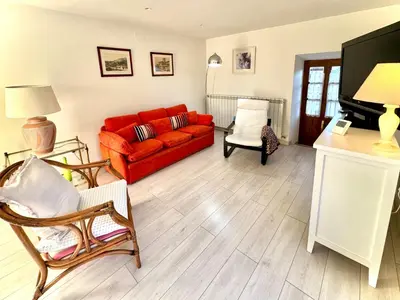a living room with a red couch and a tv at Casa Tía Milagros in Puebla de Sanabria
