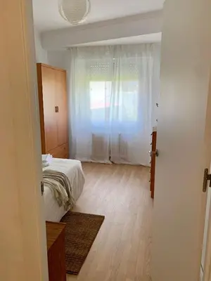 a white bedroom with a bed and a window at N&E - Home Celanova AVD San Rosendo in Celanova