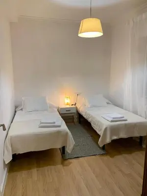 two beds in a white room with a lamp at N&E - Home Celanova AVD San Rosendo in Celanova