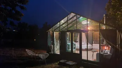 a glass house with a bed in it at night at REMANSO DE TRASFONTAO_Nido 360° in Silleda