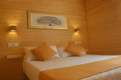 a bedroom with a bed in a wooden wall at Cabañas Compostela - Cabaña a Carballeira in Santiago de Compostela