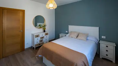 a bedroom with a large bed and a mirror at Casa Bimba in Sober