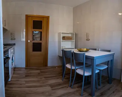a small kitchen with a blue table and chairs at Casa Bimba in Sober