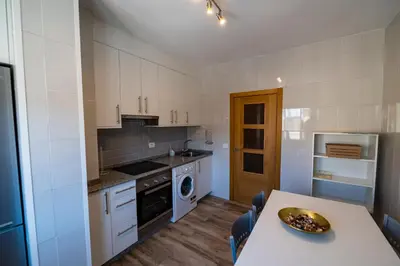 a kitchen with white cabinets and a table with a bowl on it at Casa Bimba in Sober