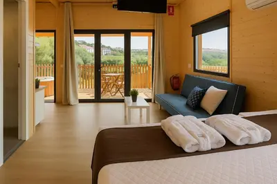 a bedroom with a bed and a blue couch at Cabañas Compostela - Cabaña A Fervenza in Santiago de Compostela
