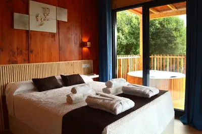 a bedroom with a bed with towels on it at Cabañas Compostela - Cabaña Pedroso con bañera de hidromasaje in Santiago de Compostela