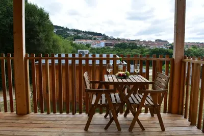a wooden table and chairs on a wooden deck at Cabañas Compostela - Cabaña Pedroso con bañera de hidromasaje in Santiago de Compostela