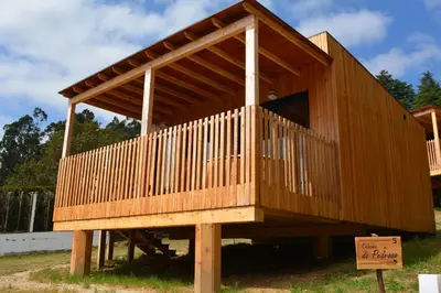 a large wooden house on display in a yard at Cabañas Compostela - Cabaña Pedroso con bañera de hidromasaje in Santiago de Compostela