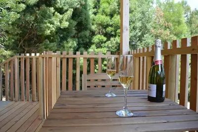 a bottle of wine and two glasses on a wooden table at Cabañas Compostela - Cabaña La Catedral con bañera de hidromasaje in Santiago de Compostela
