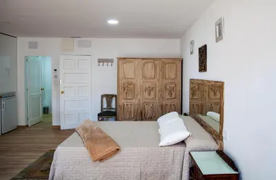 a bedroom with a large bed with a wooden headboard at A casa do Xastre in Allariz