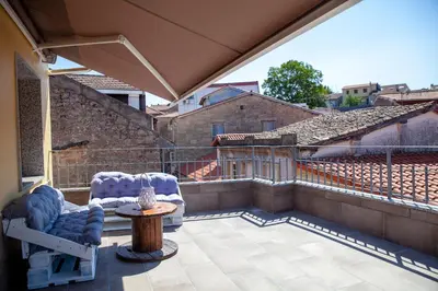 a patio with two chairs and a table on a balcony at A casa do Xastre in Allariz