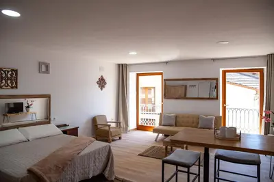 a bedroom with a bed and a living room with a table at A casa do Xastre in Allariz