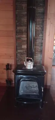 a black stove with a pot on top of it at Acogedora cabaña con piscina in Pontevedra