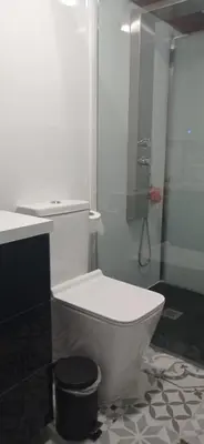 a white toilet in a bathroom with a shower at Acogedora cabaña con piscina in Pontevedra
