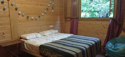 a bedroom with a bed in a log cabin at Acogedora cabaña con piscina in Pontevedra