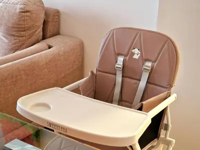a brown high chair sitting next to a couch at Apartamento Puente Romano in Ourense