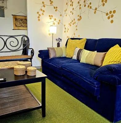 a blue couch with yellow pillows in a living room at Casa San Pablo in Melide