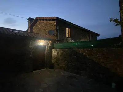 a house with a light on the side of it at night at Casal de Pedra in Santa Irene