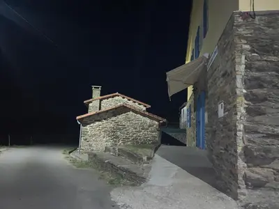 a stone building with a staircase next to a street at Casal de Pedra in Santa Irene