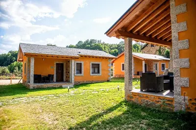 an orange house with a patio and a yard at Lagunas de Sanabria in Trefacio