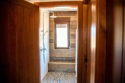 a bathroom with a walk in shower next to a window at Lagunas de Sanabria in Trefacio