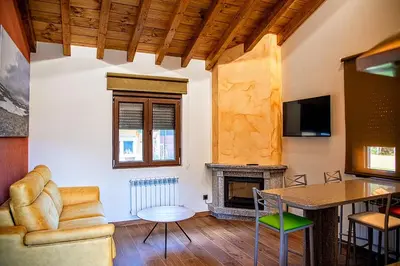 a living room with a couch and a fireplace at Lagunas de Sanabria in Trefacio