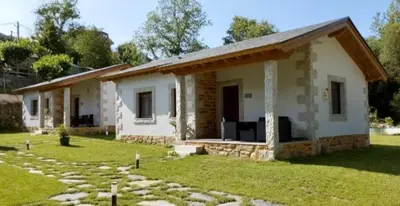 a small white house with a grass yard at Lagunas de Sanabria in Trefacio