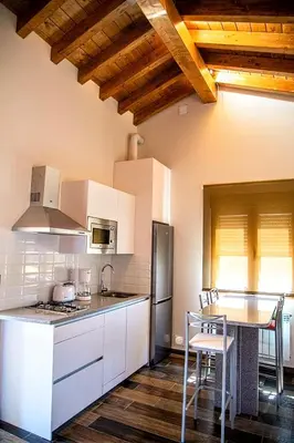 a kitchen with white cabinets and a table with chairs at Lagunas de Sanabria in Trefacio