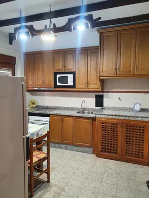 a kitchen with wooden cabinets and a microwave at Casa Celedonio in Cerredo