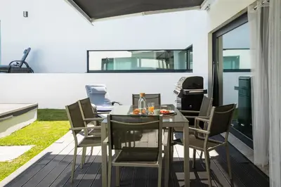 a home with large glass doors and a courtyard at Villa con piscina y jardín, Santiago de Compostela in Teo