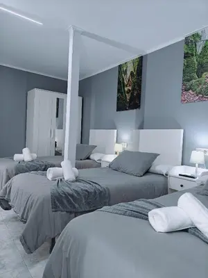 three beds in a room with blue walls at Casa de Fernando in Tríacastela