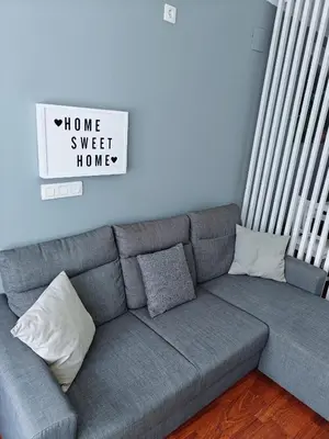 a couch in a living room with a home sweet home sign at Casa de Fernando in Tríacastela