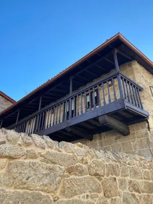 a wooden balcony on the side of a stone wall at Celanova House in Celanova