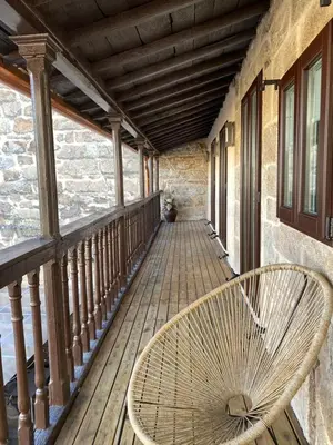 a rattan chair sitting on a wooden porch at Celanova House in Celanova