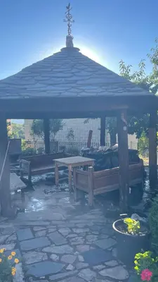 a wooden gazebo with benches and a table at Casa Gelito in Espinareda de Vega
