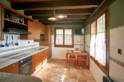 a kitchen with a table and two chairs in it at Casa Gelito in Espinareda de Vega