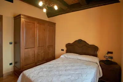 a bedroom with a large bed and a wooden cabinet at Casa Gelito in Espinareda de Vega