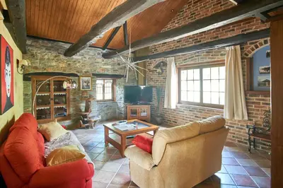 a living room with two couches and a brick wall at Casa Gelito in Espinareda de Vega