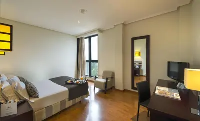 a room with a bed and a desk and a television at Exe Auriense in Ourense