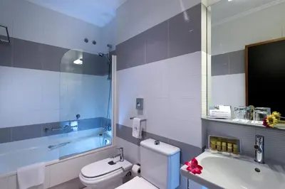 a bathroom with a toilet and a sink and a tub at Exe Auriense in Ourense
