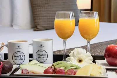 two glasses of orange juice and fruit on a tray at Exe Auriense in Ourense