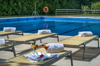 a group of picnic tables next to a swimming pool at Exe Auriense in Ourense