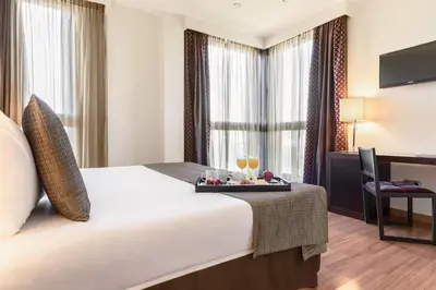 a hotel room with a bed with a tray with drinks on it at Exe Auriense in Ourense