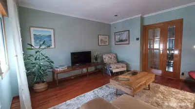 a living room with a couch and a tv at Duplex acogedor CAMINO INGLÉS a 10 min de Santiago in Sigüeiro