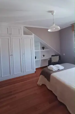 a living room with a chair and a staircase at Duplex acogedor CAMINO INGLÉS a 10 min de Santiago in Sigüeiro