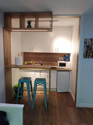 a kitchen with two stools and a table with a microwave at Precioso loft a 600m de la catedral in Santiago de Compostela