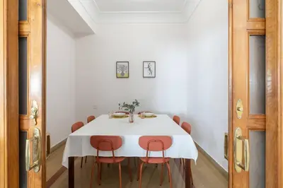 a dining room with a white table and orange chairs at Casa Bogart Apto 5 dormitorios in Ourense