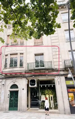 a woman is walking in front of a building at Casa Bogart Apto 5 dormitorios in Ourense