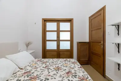 a bedroom with a bed with a floral bedspread and a door at Casa Bogart Apto 5 dormitorios in Ourense