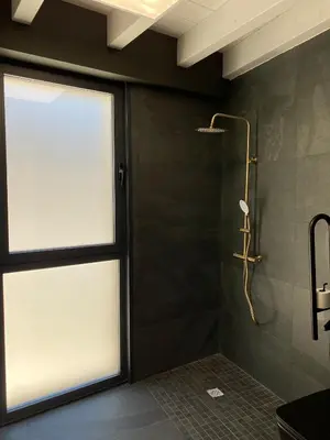 a bathroom with a shower with a glass window at A PONTEVELLA Alojamiento Boutique, Sobradelo in Sobradelo